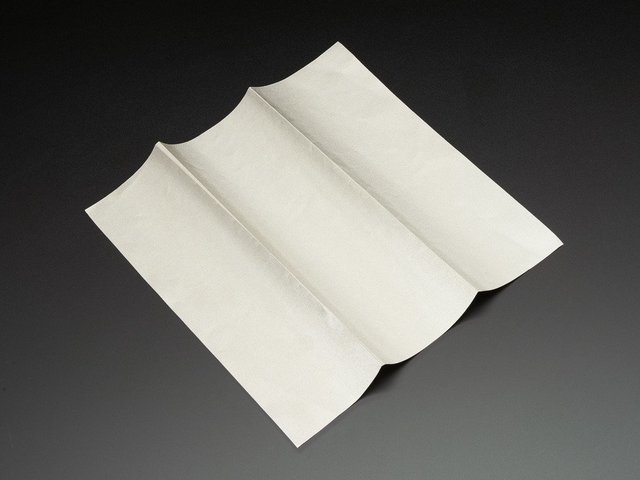 A folded square of silver-grey woven conductive fabric.