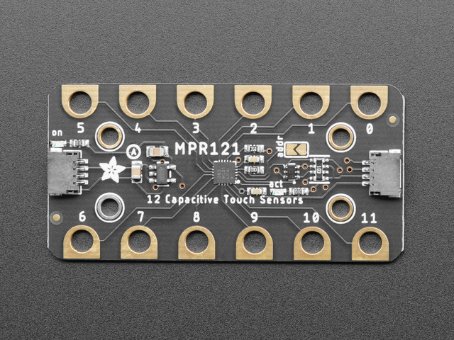 The MPR121 touch board: twelve numbered gold pads around its edge and a STEMMA QT connector at each end.