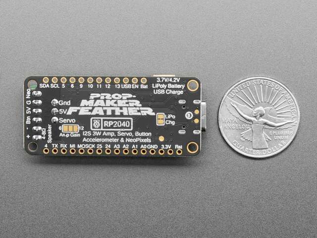 The back of the RP2040 Prop-Maker Feather beside a US quarter, its silkscreen naming the pins, the Neo, 5V, G, Btn and speaker terminals and the Servo header.