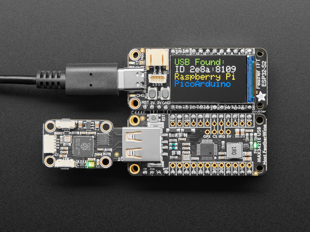 The USB Host FeatherWing stacked with a Feather board and a small display reading "USB Found".